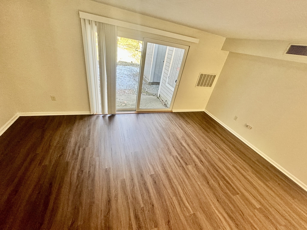 13 Beal's Cove Road, Unit E Hingham, MA 02043 - Photo 11 of 20 a view of an empty room with wooden floor and a window