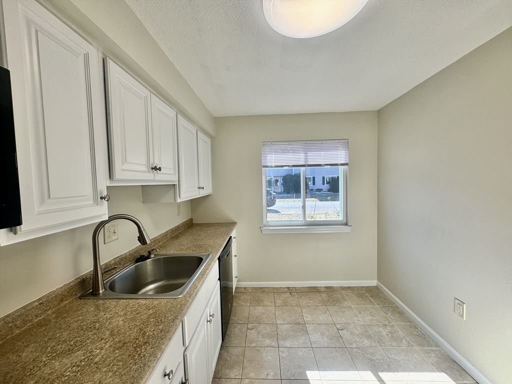 13 Beal's Cove Road, Unit E Hingham, MA 02043 - Photo 4 of 20 a kitchen with a sink a stove and cabinets