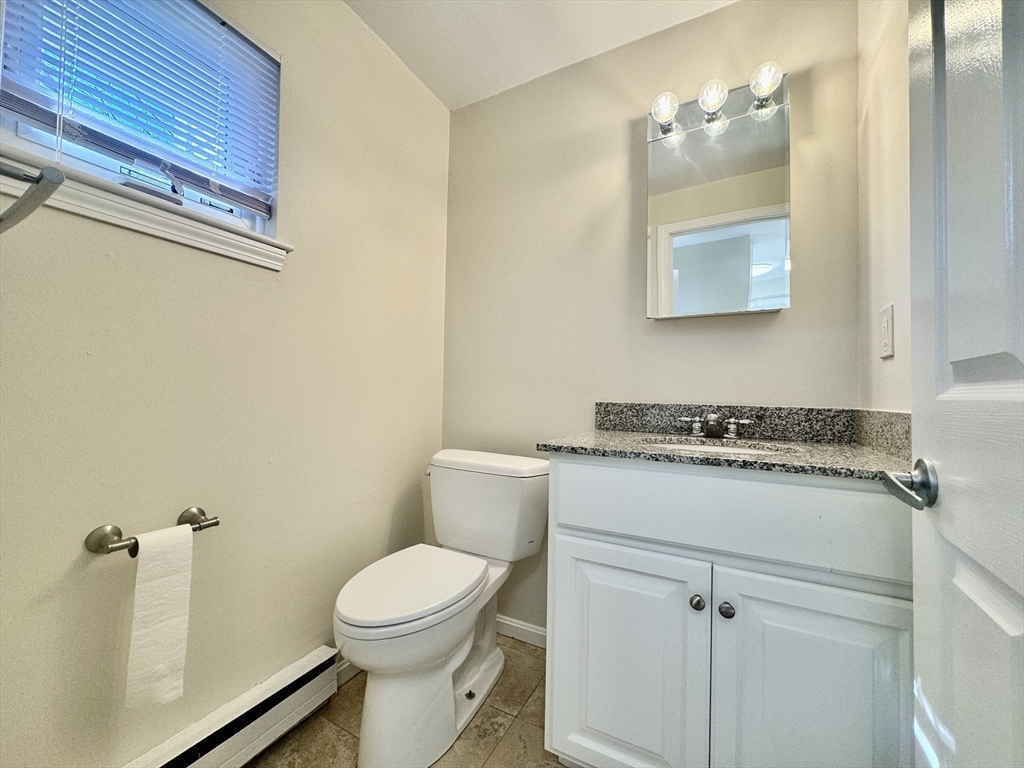 13 Beal's Cove Road, Unit E Hingham, MA 02043 - Photo 7 of 20 a bathroom with a sink a toilet and mirror