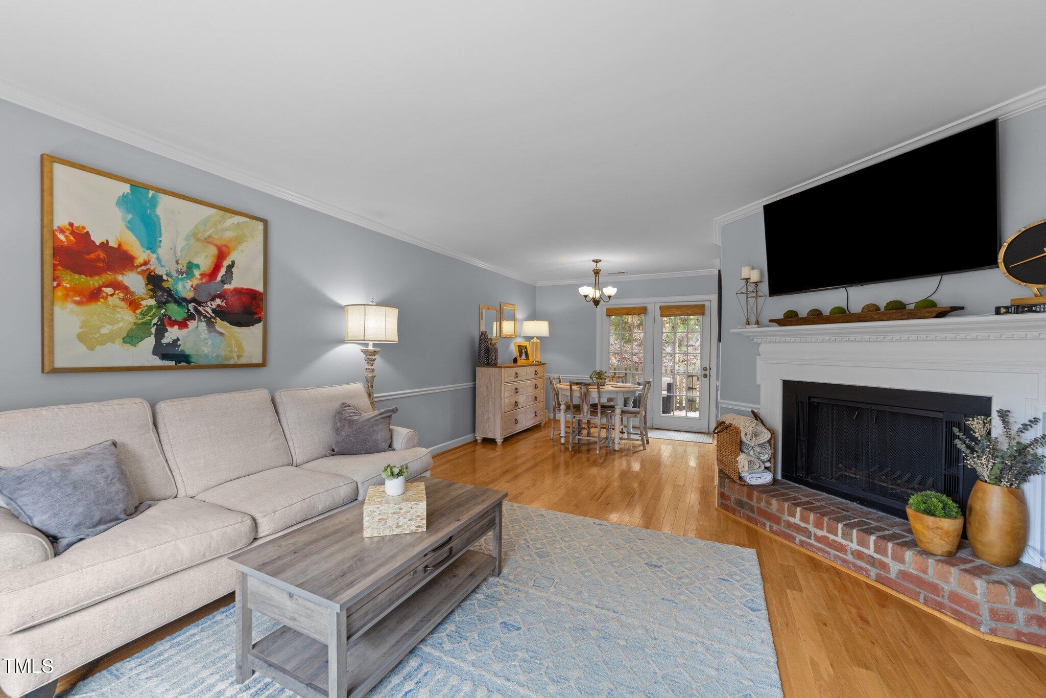 1334 Baez Street Raleigh, NC 27608 - Photo 3 of 28 a living room with furniture a flat screen tv and a fireplace