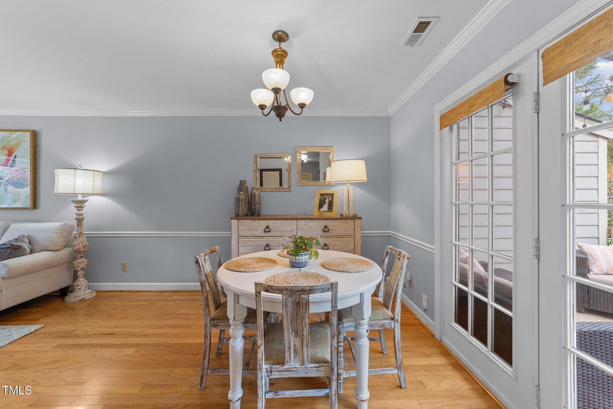 1334 Baez Street Raleigh, NC 27608 - Photo 7 of 28 a view of a dining room with furniture a chandelier and wooden floor