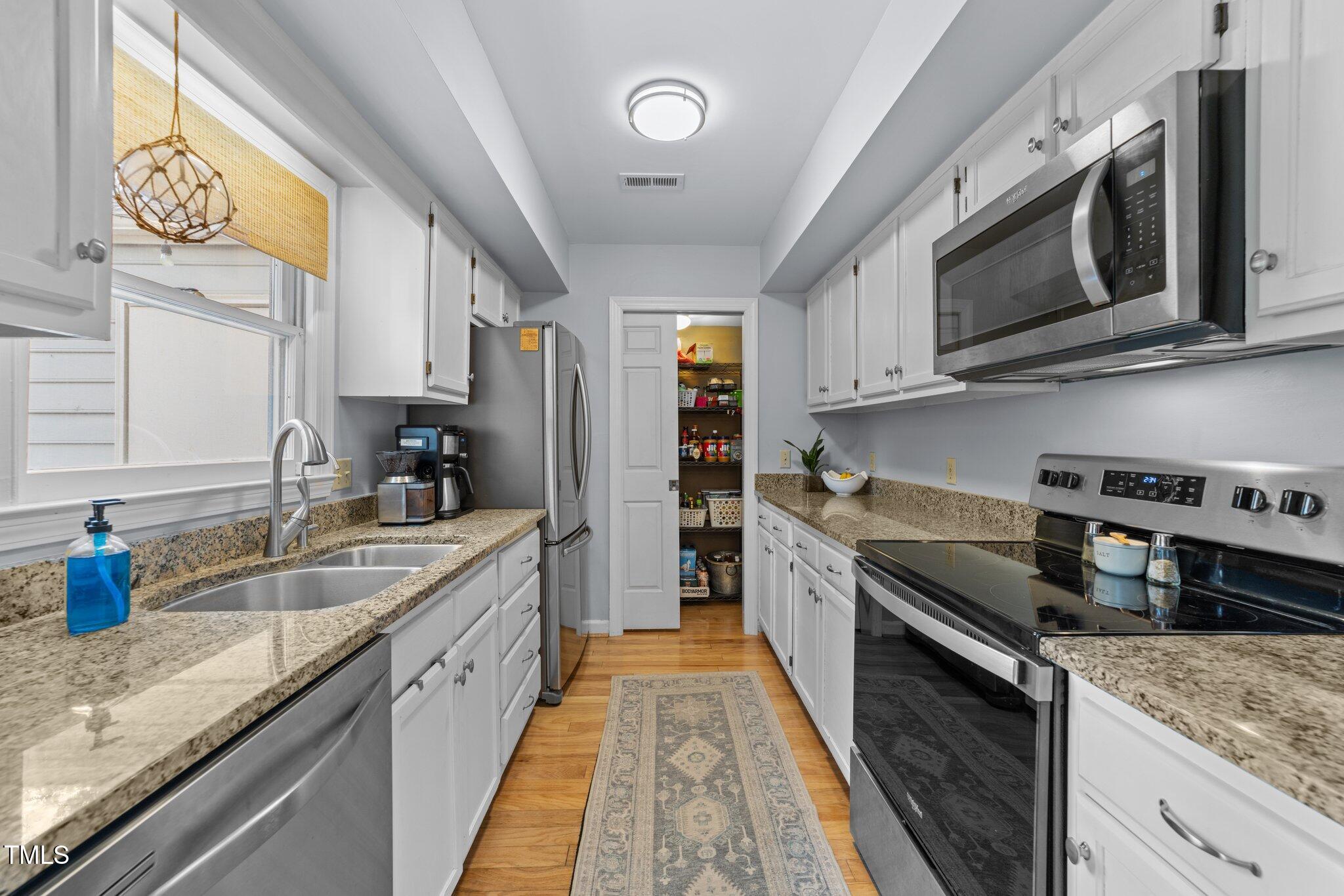 1334 Baez Street Raleigh, NC 27608 - Photo 8 of 28 a large kitchen with stainless steel appliances granite countertop a stove and a sink
