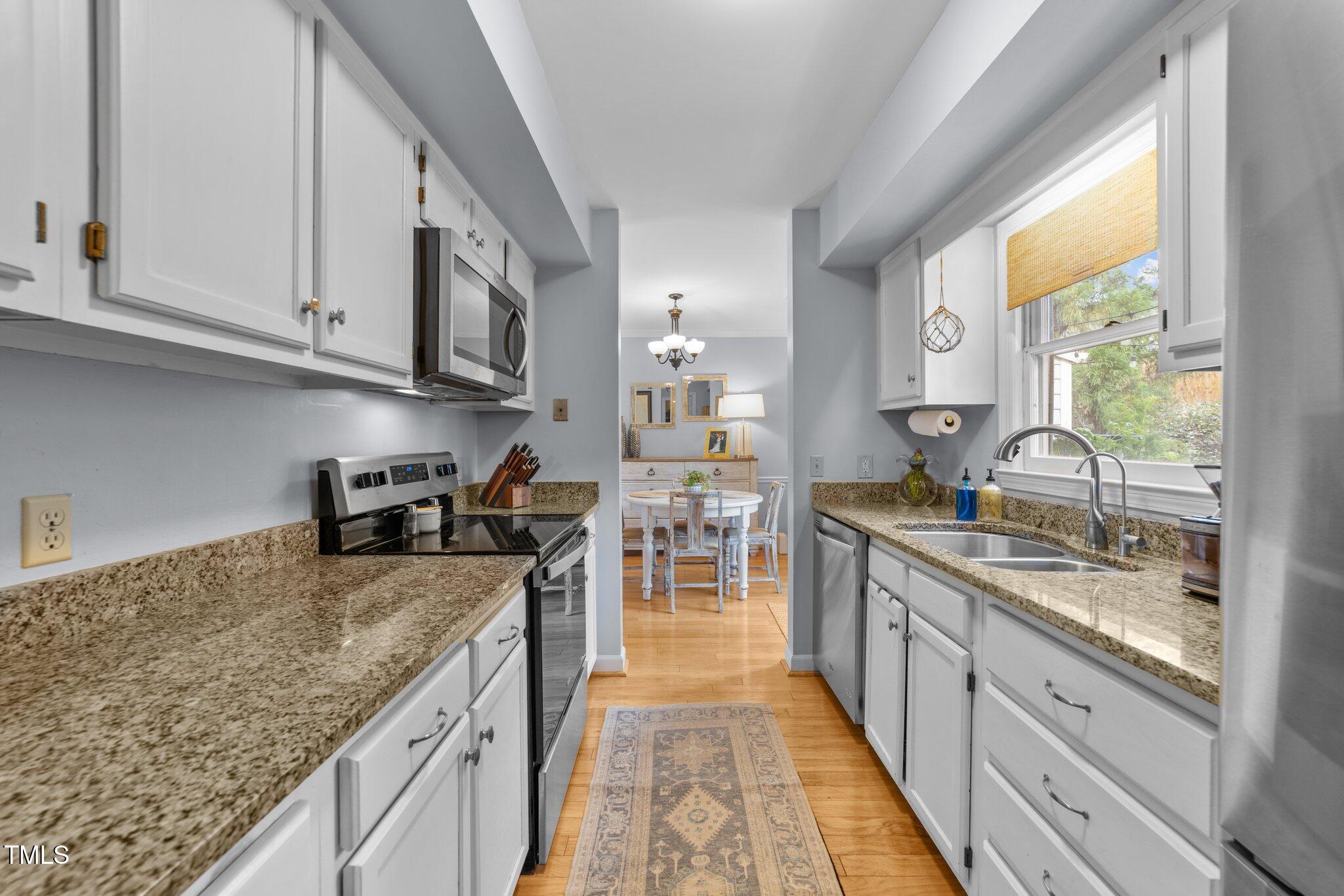 1334 Baez Street Raleigh, NC 27608 - Photo 9 of 28 a kitchen with stainless steel appliances granite countertop a stove a sink and a microwave