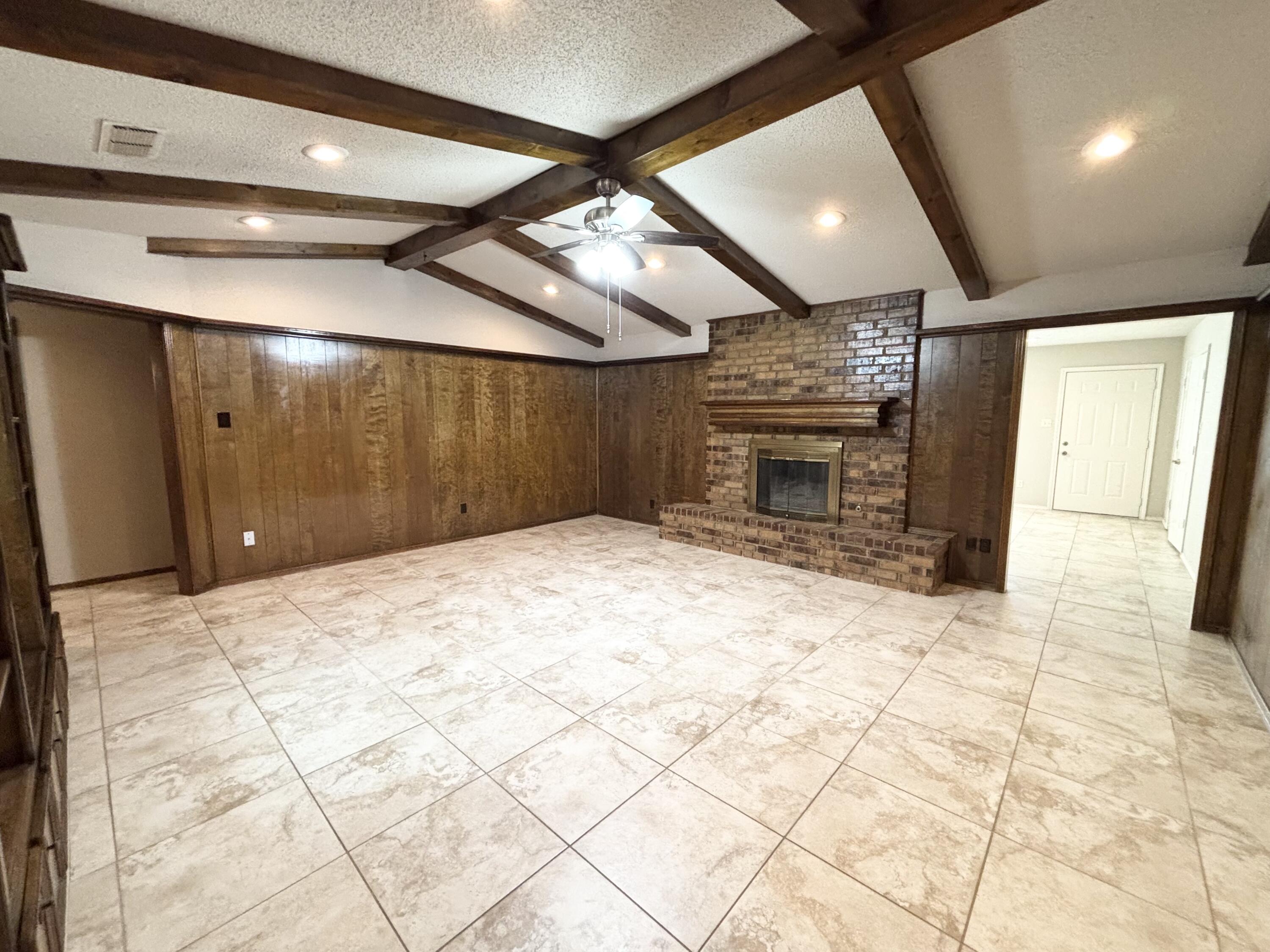 4913 62nd Street Lubbock, TX 79414 - Photo 4 of 22 a large room with a fireplace and chandelier