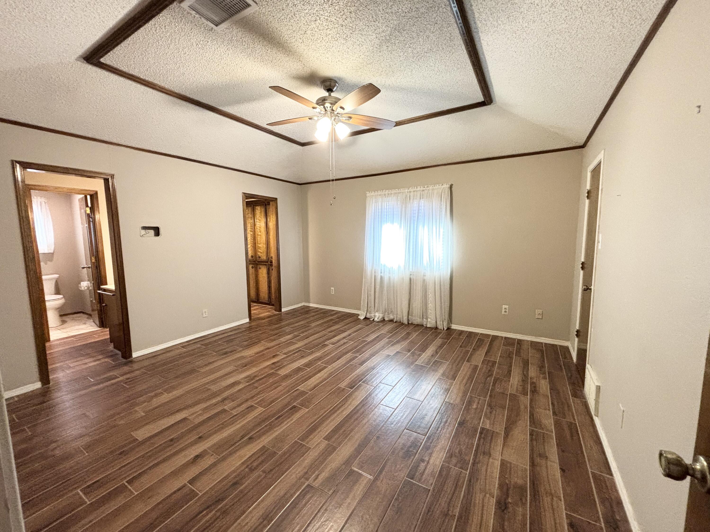 4913 62nd Street Lubbock, TX 79414 - Photo 10 of 22 a view of an empty room with wooden floor