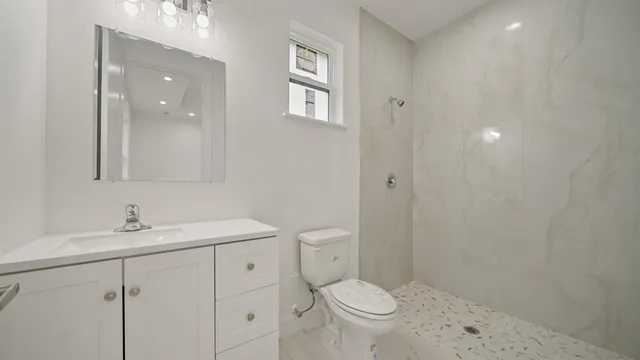 a bathroom with a sink a toilet and shower