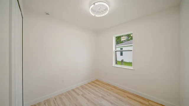 a view of room with window and wooden floor