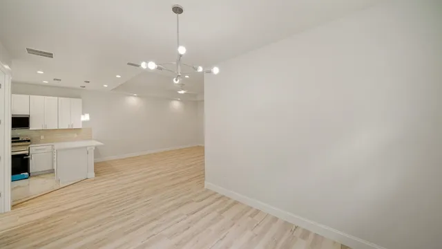 a view of a kitchen with a dishwasher and a wooden floor