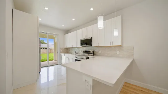a kitchen with a sink a microwave a stove and cabinets