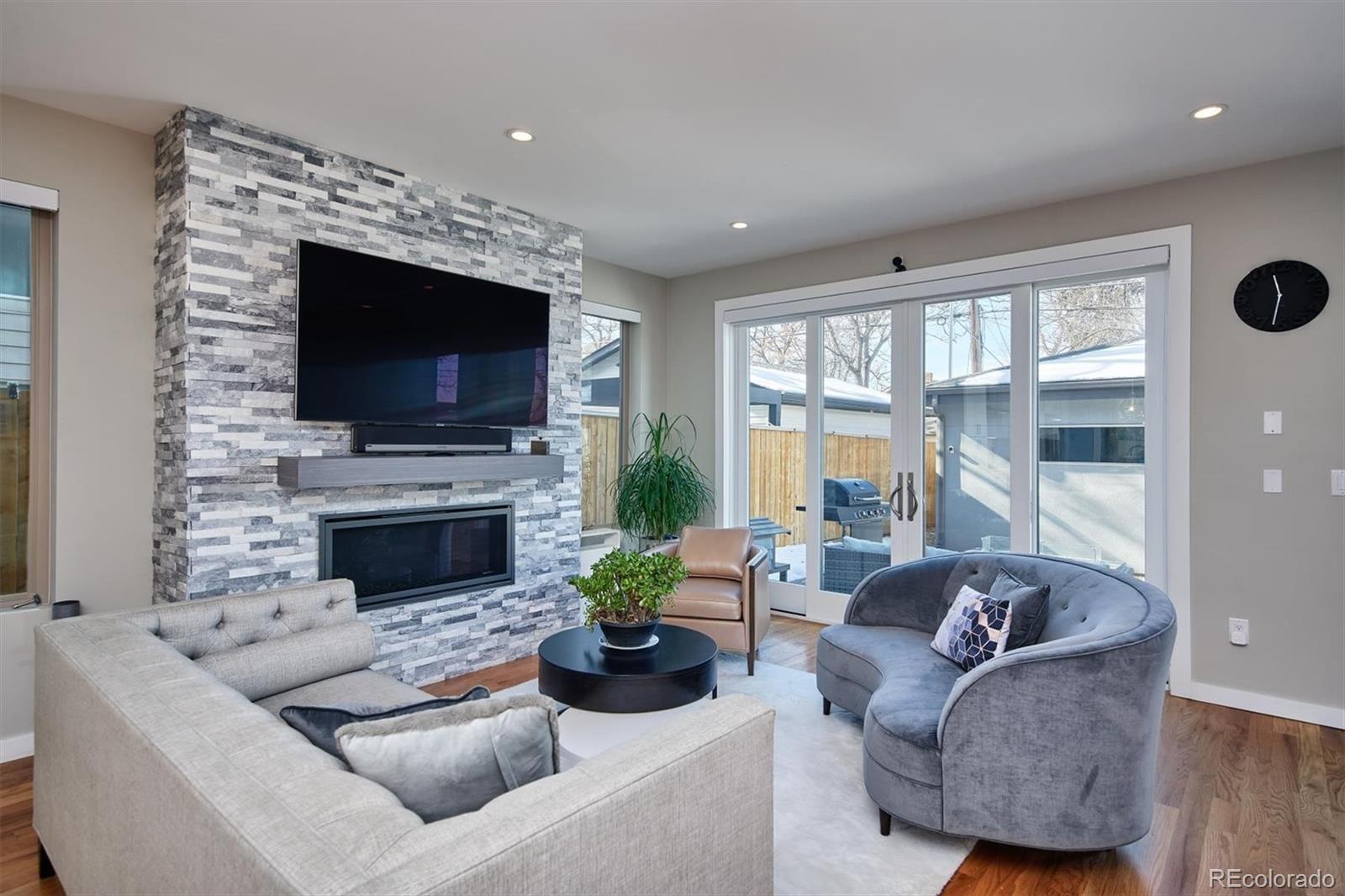 4583 Utica Street Denver, CO 80212 - Photo 11 of 40 a living room with furniture a flat screen tv and a fireplace