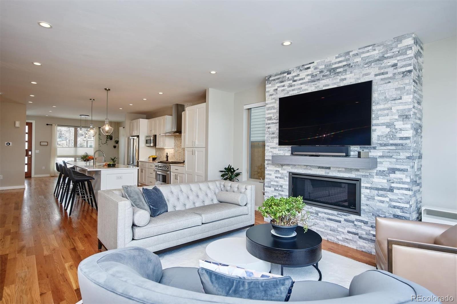 4583 Utica Street Denver, CO 80212 - Photo 12 of 40 a living room with furniture a flat screen tv and a fireplace