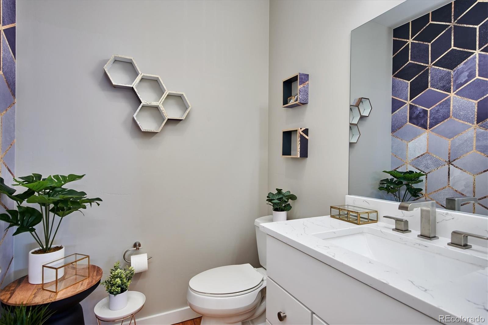 4583 Utica Street Denver, CO 80212 - Photo 15 of 40 a bathroom with a granite countertop toilet a sink and a mirror