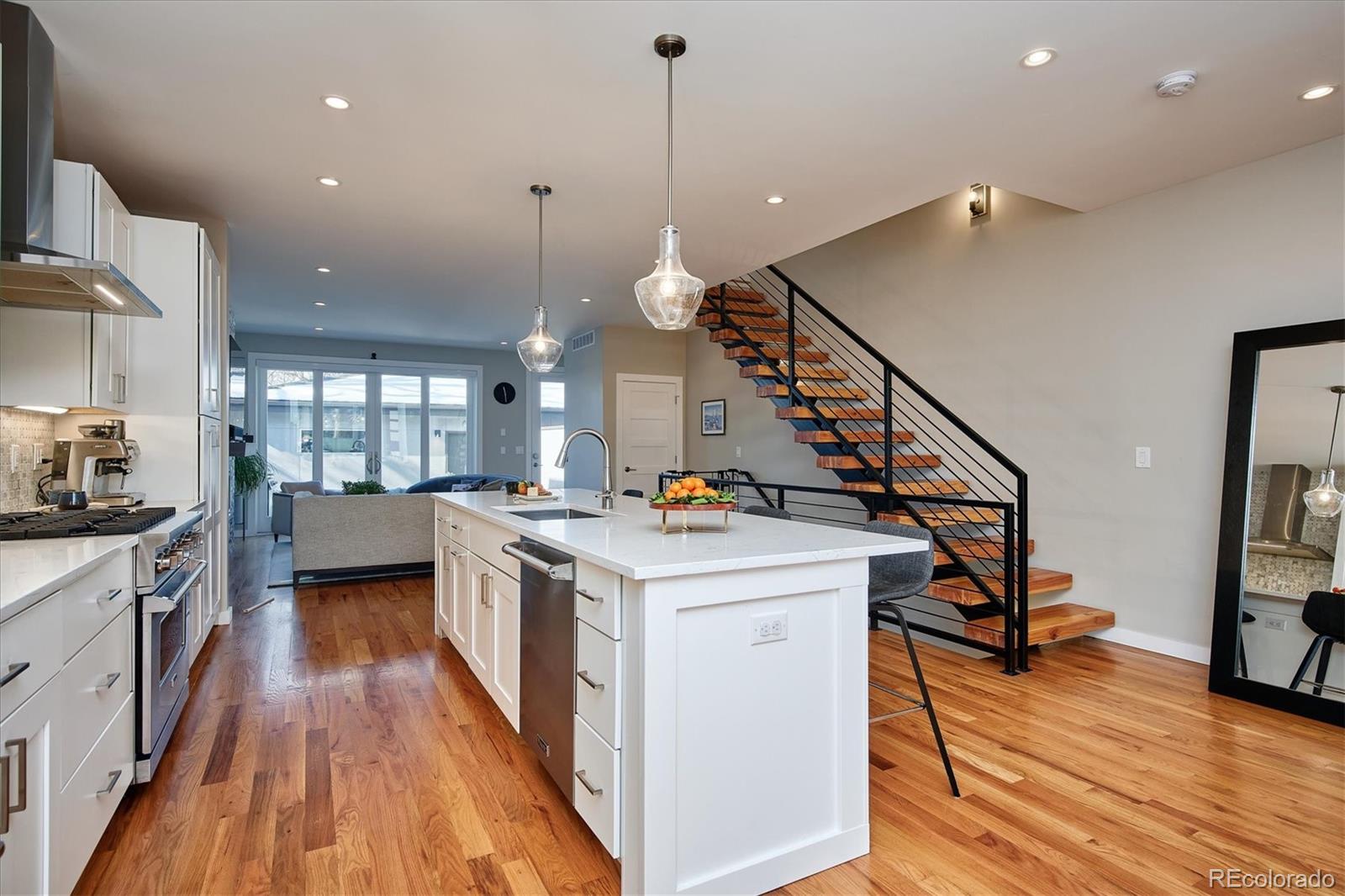 4583 Utica Street Denver, CO 80212 - Photo 7 of 40 a kitchen that has a lot of cabinets and wooden floor