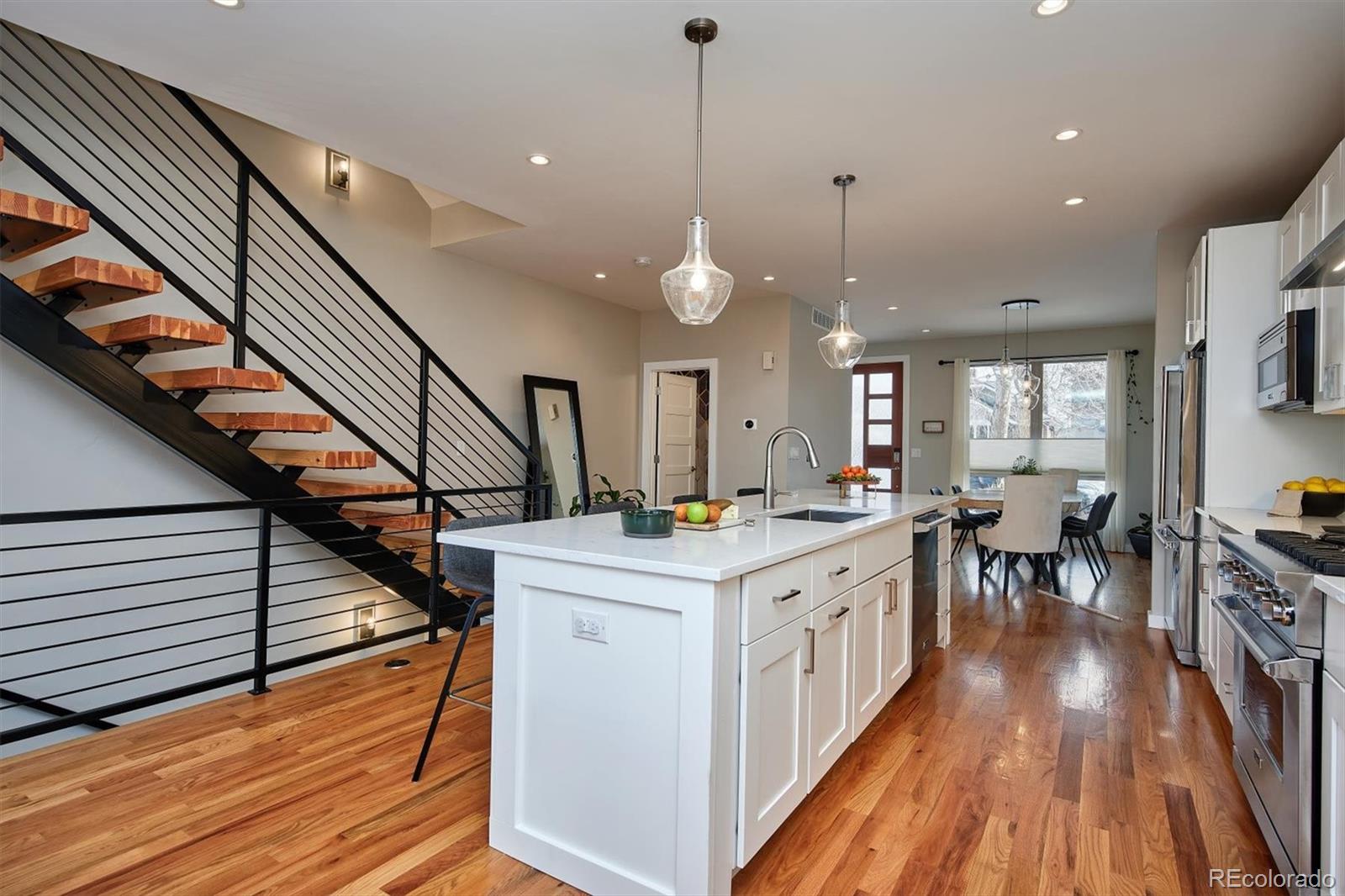 4583 Utica Street Denver, CO 80212 - Photo 10 of 40 a kitchen with wooden floors and white cabinets
