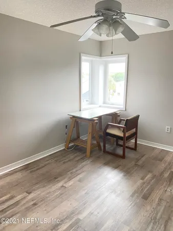 a workspace with chandelier fan and window