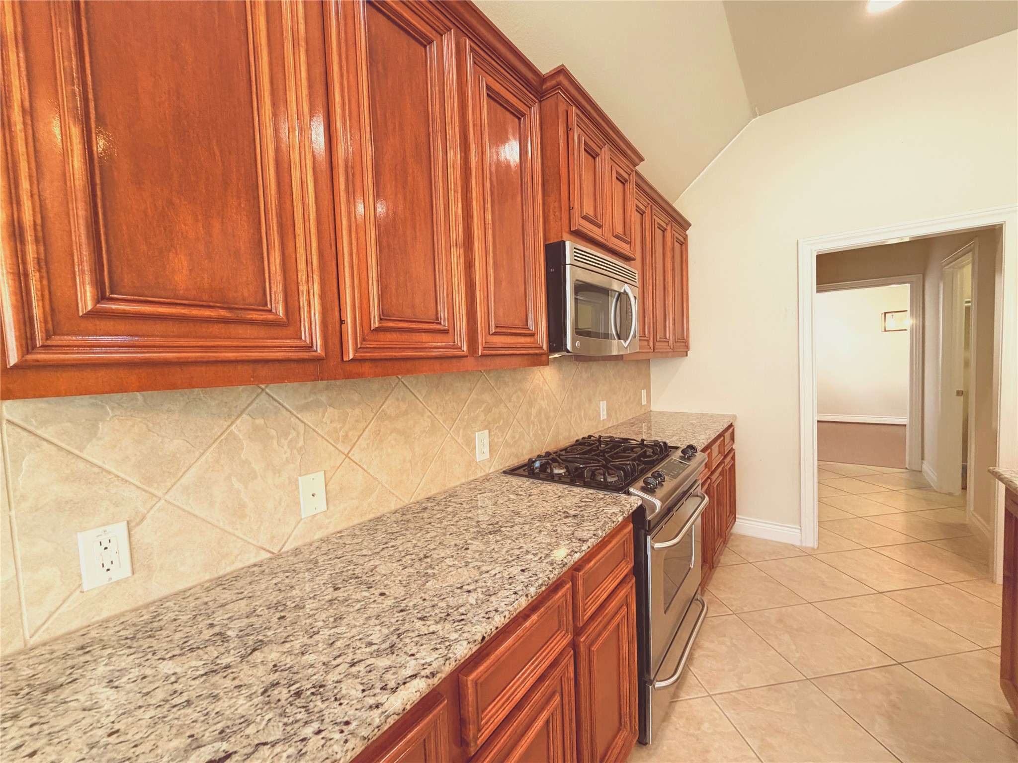 22015 Rustic Canyon Lane Richmond, TX 77469 - Photo 13 of 26 a kitchen with granite countertop a sink a stove and cabinets