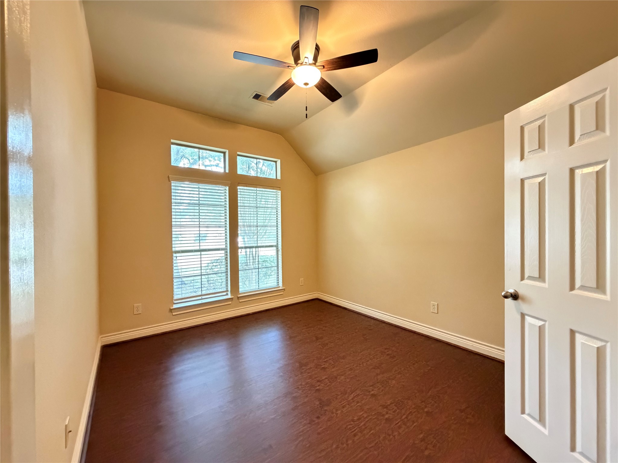 22015 Rustic Canyon Lane Richmond, TX 77469 - Photo 21 of 26 an empty room with wooden floor fan and windows