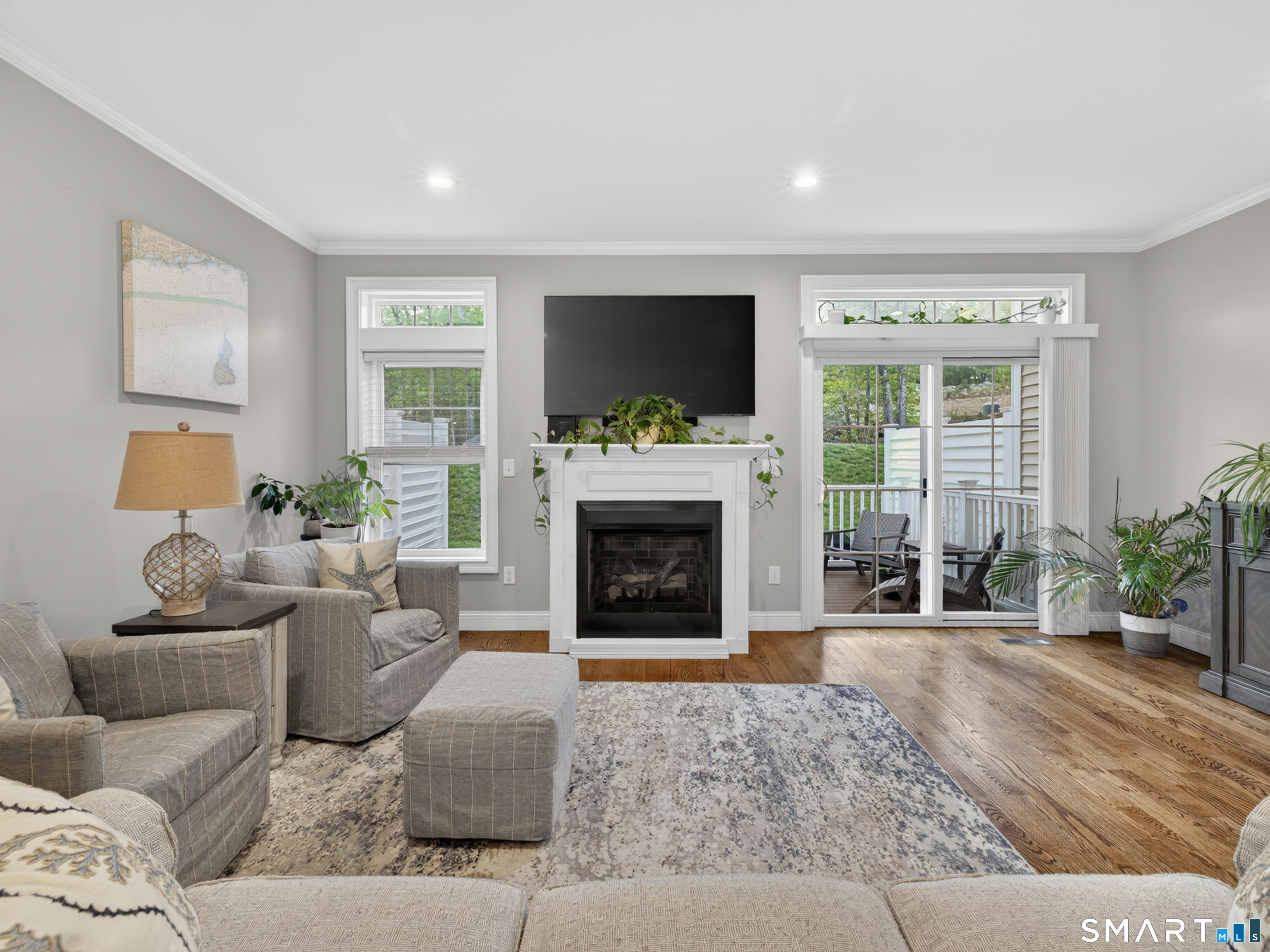 34 Village Crossing, Unit 34 Niantic, CT 06357 - Photo 11 of 38 a living room with furniture a flat screen tv and a fireplace
