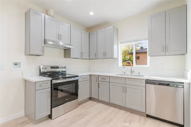 a kitchen with white cabinets stainless steel appliances and sink