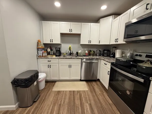 a white kitchen with sink and white stainless steel appliances
