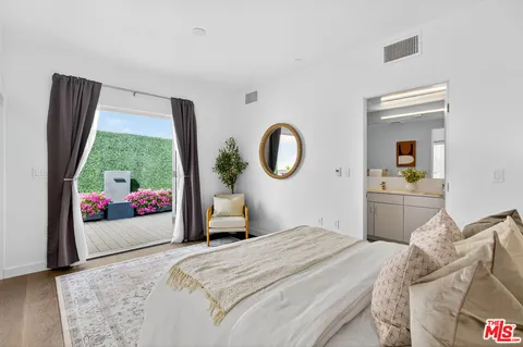 a bedroom with a bed and a dresser next to a window