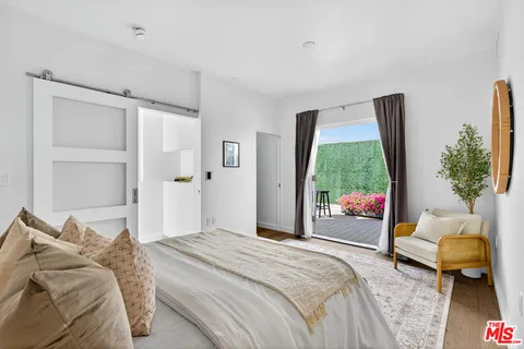 a bedroom with a bed couch and a window