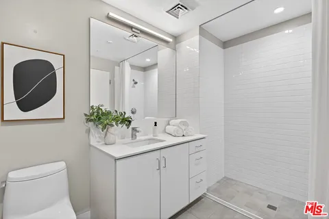 a bathroom with a sink a toilet and mirror