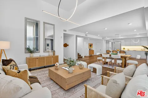 a living room with furniture and view of kitchen