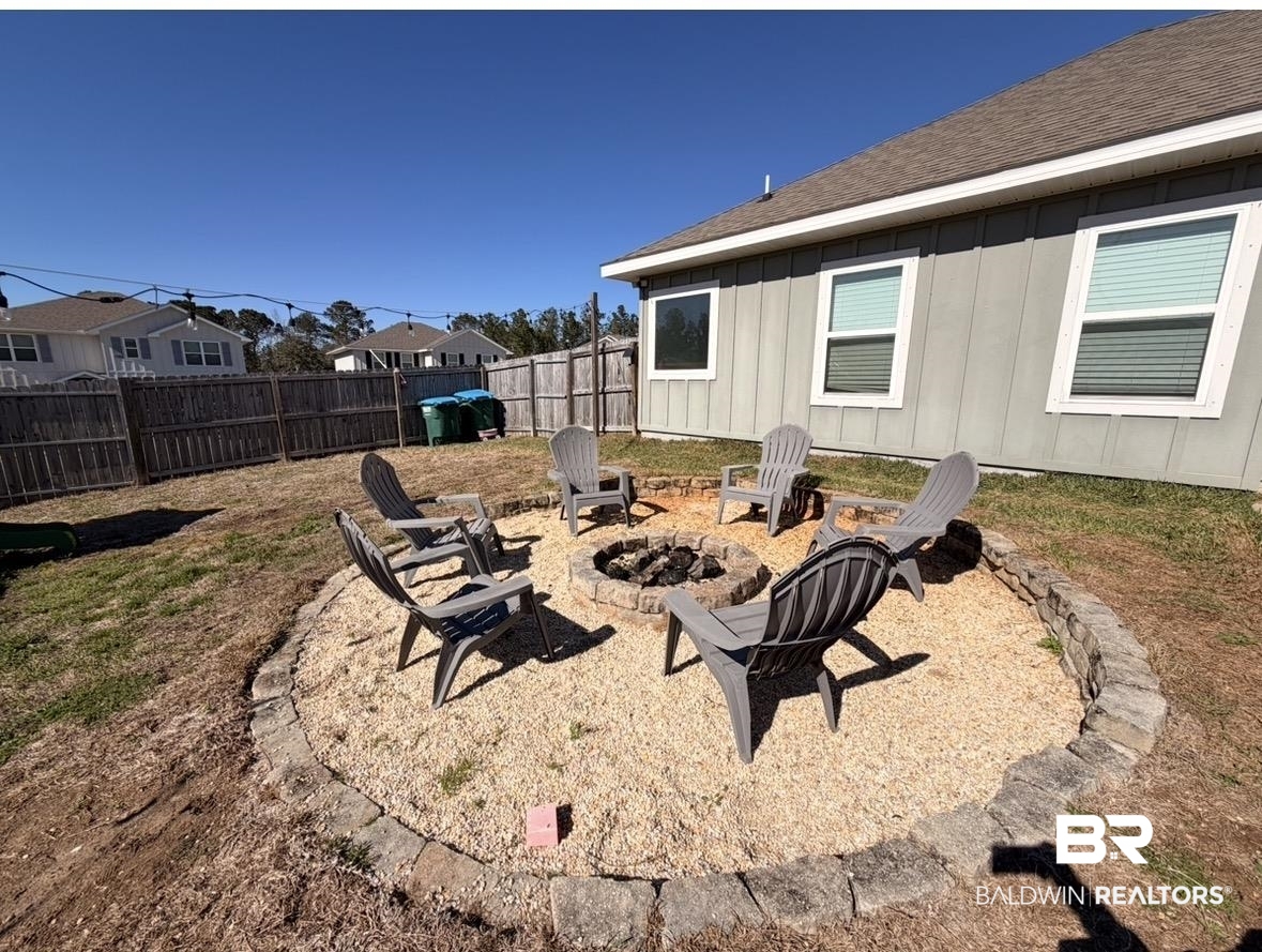 32215 Calder Court Daphne, AL 36527 - Photo 12 of 13 Fenced backyard featuring a patio area, a residential view, and an outdoor fire pit