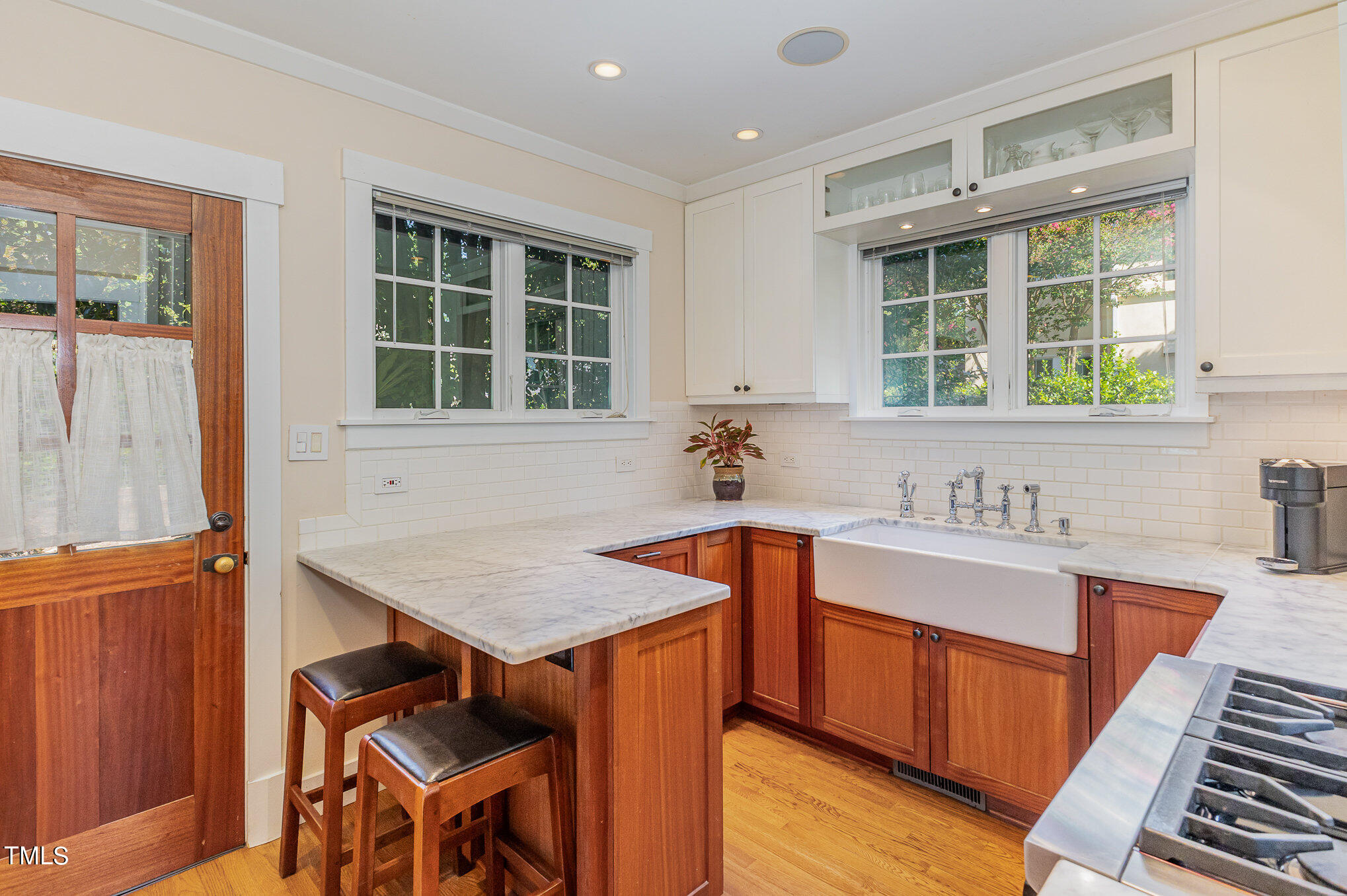 1629 St Marys Street Raleigh, NC 27608 - Photo 15 of 39 Carrera marble counters, Mahogany cabinets and farm sink in this updated Kitchen.