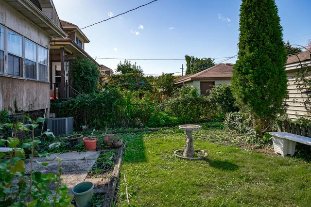 a view of a chair and table in backyard of the house