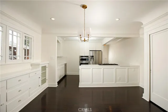 a kitchen with cabinets and wooden floor