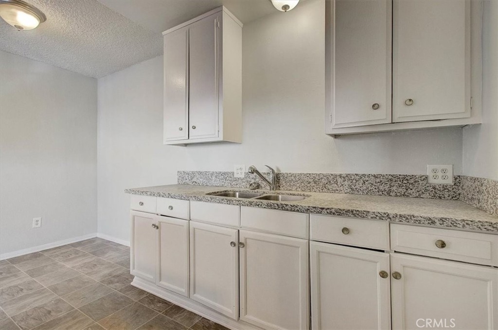 2122 East 10th Street Long Beach, CA 90804 - Photo 11 of 75 a kitchen with granite countertop white cabinets and sink