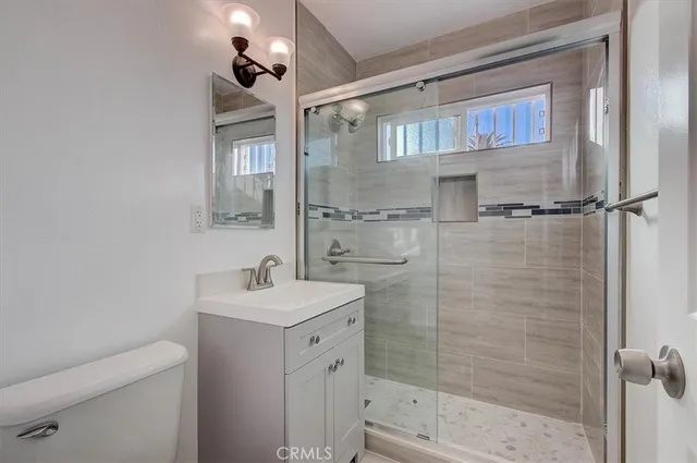 a bathroom with a shower sink vanity and toilet