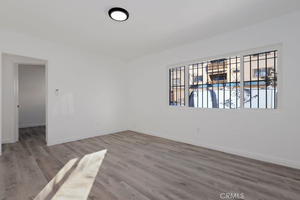 2122 East 10th Street Long Beach, CA 90804 - Photo 21 of 75 an empty room with wooden floor and windows