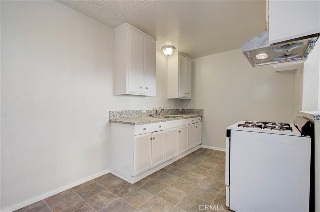 2122 East 10th Street Long Beach, CA 90804 - Photo 9 of 75 a room with a stove a sink dishwasher and a refrigerator