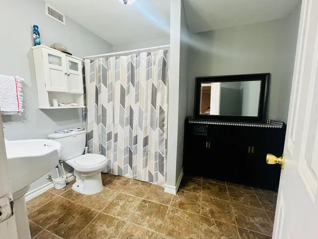 a bathroom with a sink toilet and shower