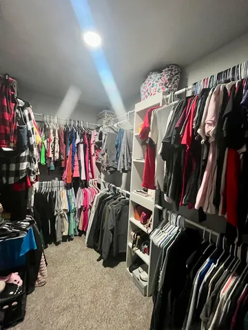a view of walk in closet with clothes