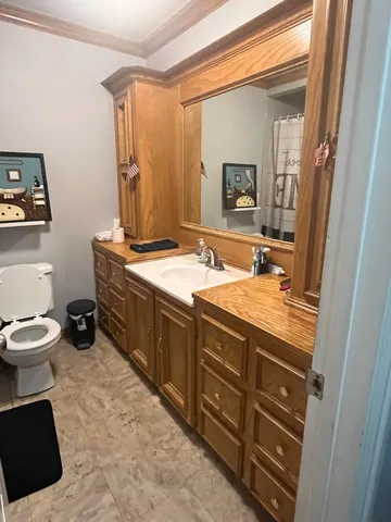 a bathroom with a sink toilet and mirror