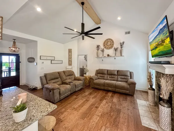 a living room with furniture a flat screen tv and a fireplace