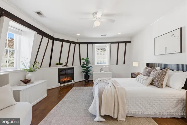 a spacious bedroom with a bed a fireplace and a large window