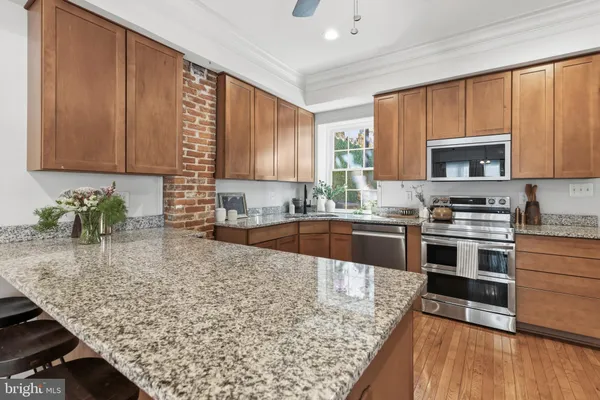 a kitchen with stainless steel appliances granite countertop a stove a sink and a microwave