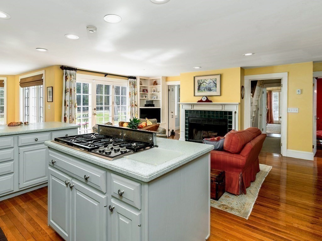 156 Larch Row Wenham, MA 01984 - Photo 12 of 38 a kitchen with stainless steel appliances granite countertop a stove and a fireplace