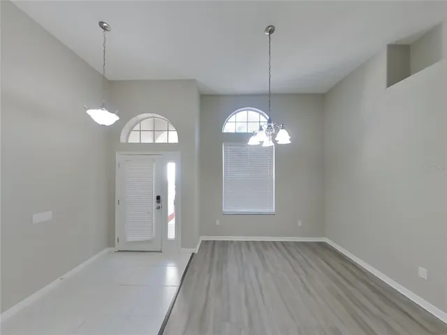 a view of a room with wooden floor and chandelier