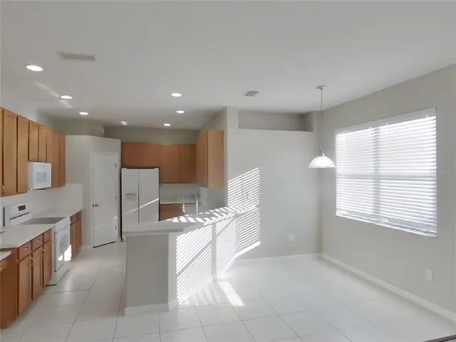 a large white kitchen with a large window