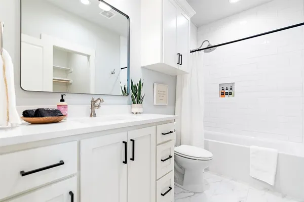 a bathroom with a sink a toilet and shower