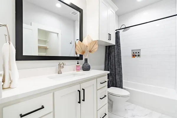 a bathroom with a sink a toilet and shower