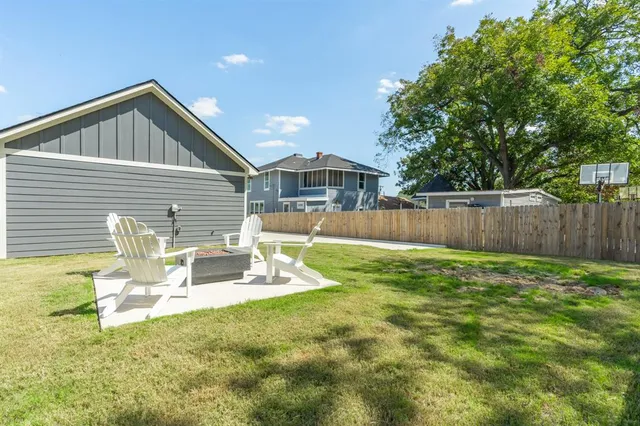 a view of a house with backyard and sitting area