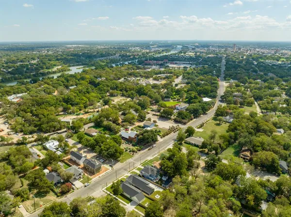 an aerial view of residential houses with outdoor space and trees