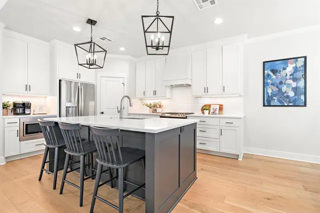a kitchen with a table chairs and white cabinets